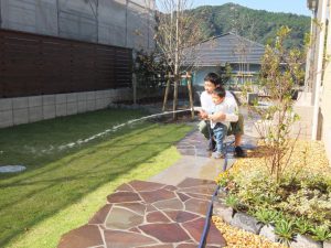 砂場とテラスで子供が遊べる庭