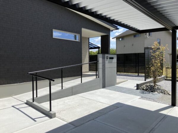 グレーの門壁にシンボルツリーが映える新築